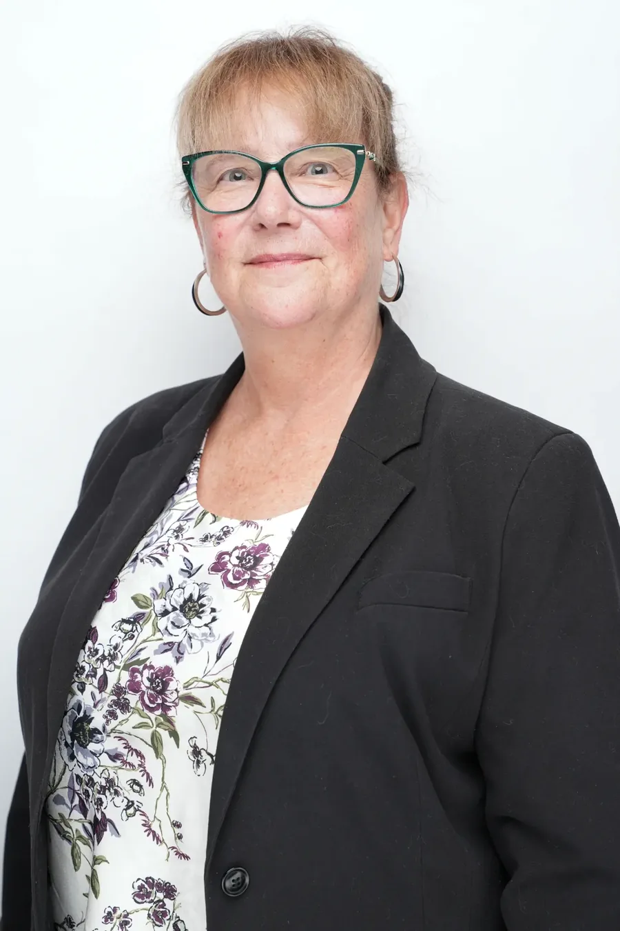 Jennifer Martin Shaw wearing glasses and a dark blazer